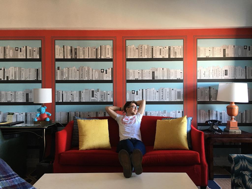 Elliot Ruggles sitting on a couch surrounded by books